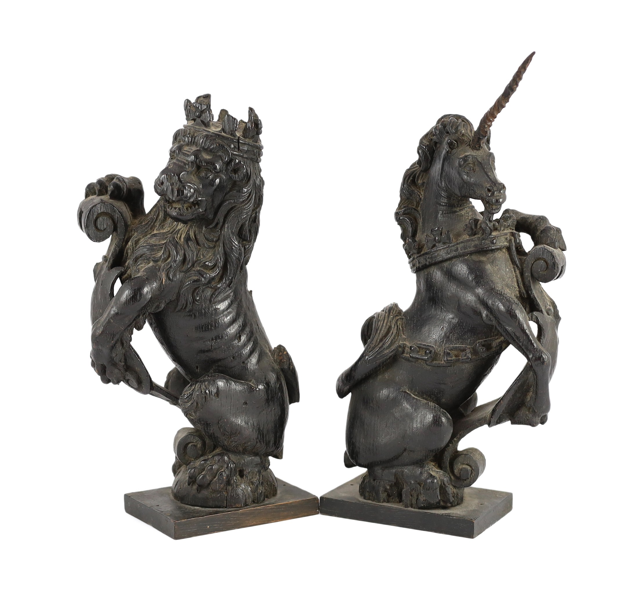 A pair of 18th century carved and ebonised oak heraldic beasts, lion and unicorn, 42cm high